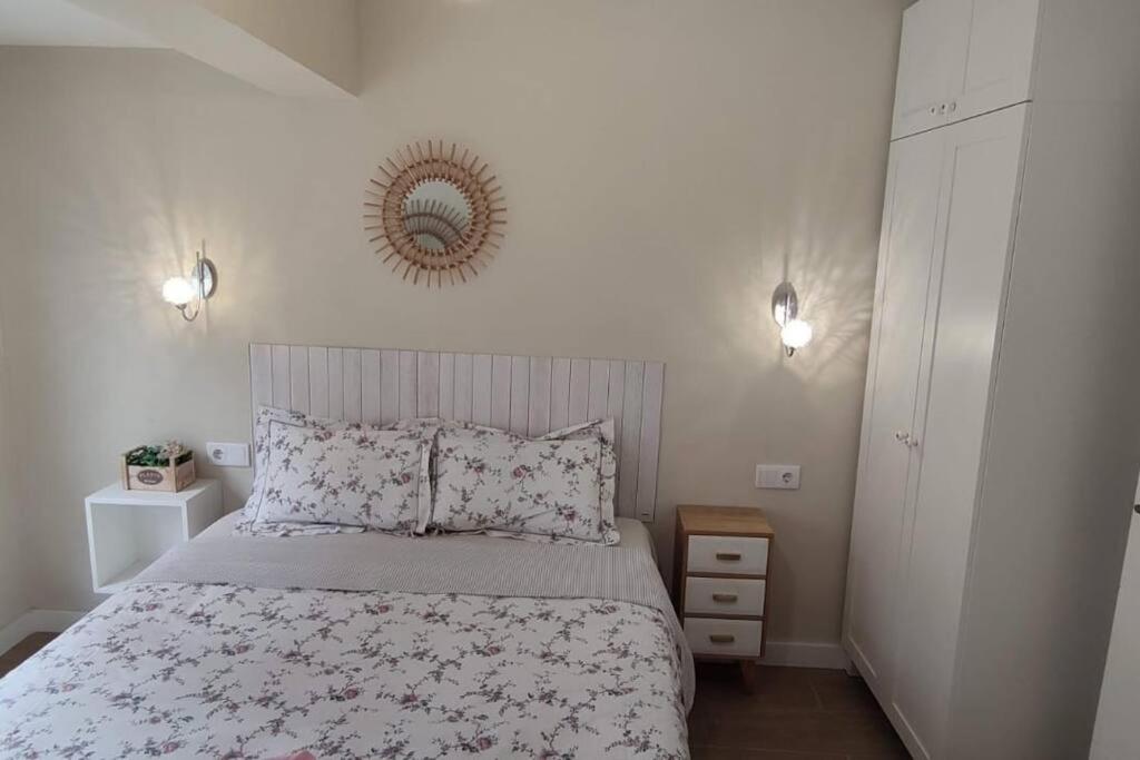1 dormitorio con cama y espejo en la pared en Parque Playa II, en Gijón