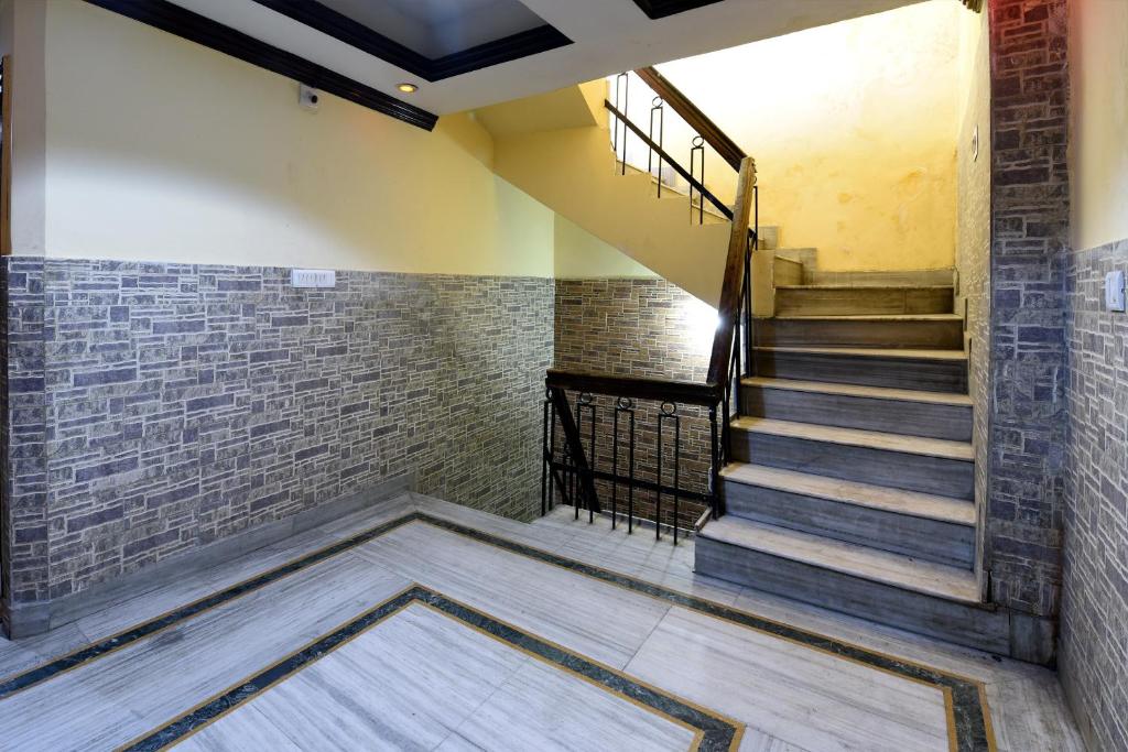 uma escada num quarto com uma parede de tijolos em OYO Hotel Jammu Palace em Jamu