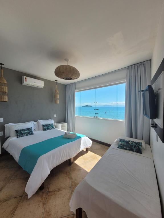 a bedroom with two beds and a view of the ocean at Bamboo Búzios Hostel in Búzios