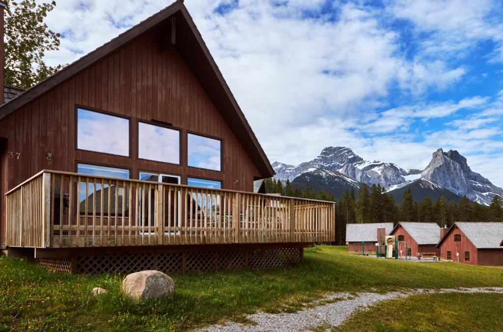 una casa con terrazza e montagne sullo sfondo di Banff Gate Mountain Resort a Canmore