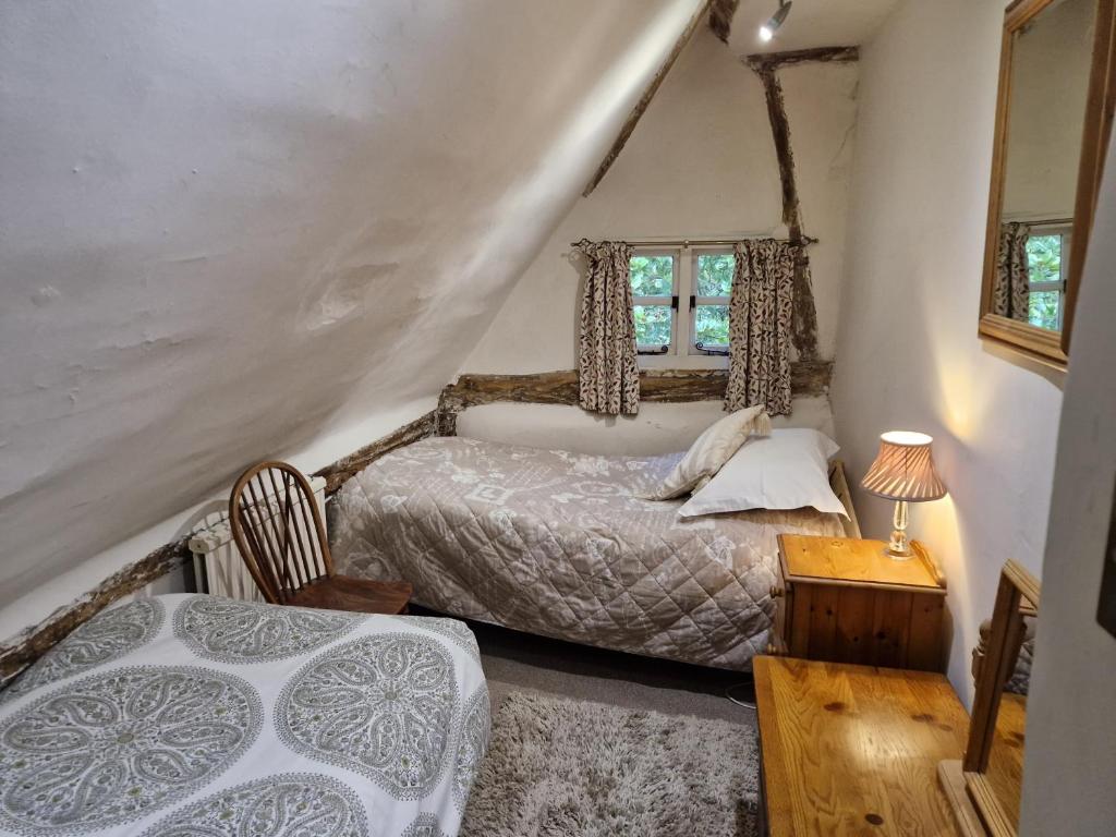 a bedroom with two beds and a window at Delightful 3bed thatched Cottage in Stockbridge