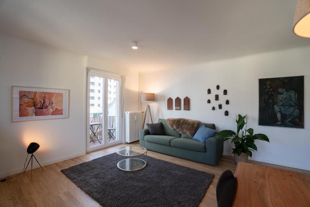 a living room with a couch and a table at Jungstay Apartments- near Basel in Basel