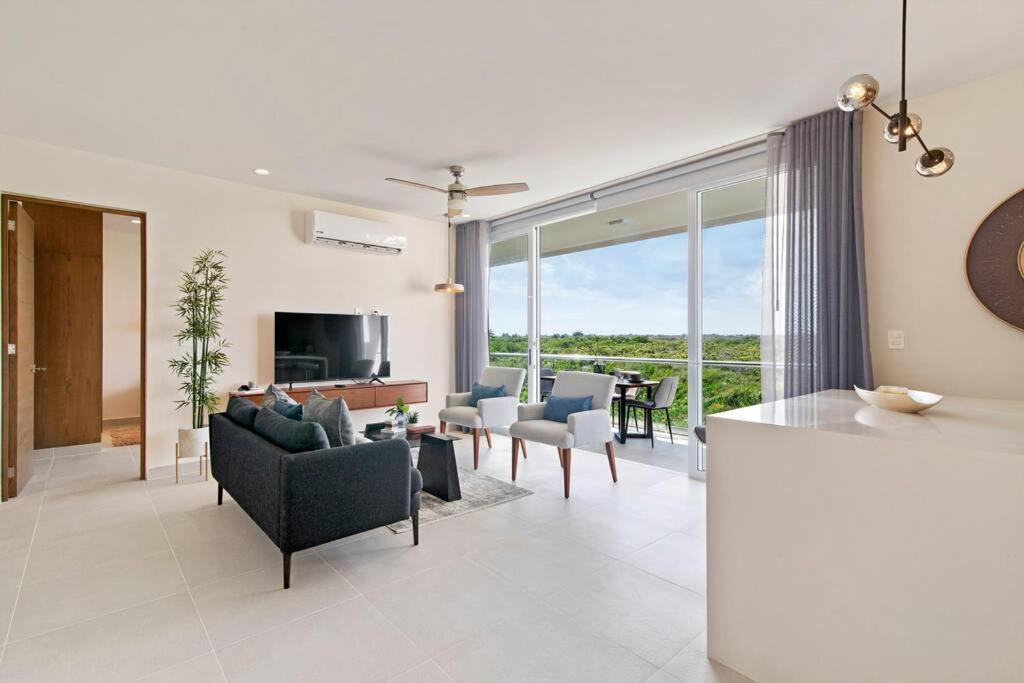 a living room with a couch and chairs and a table at Jungle Joy Prv Jacuzzi Beach Access Rooftop Pools W Sea Views + Beach Club in Akumal