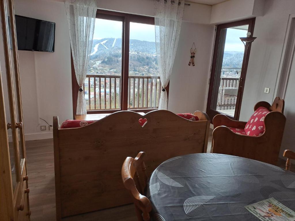 a room with a table and chairs and a balcony at Appartement résidence Les Dryades in Gérardmer
