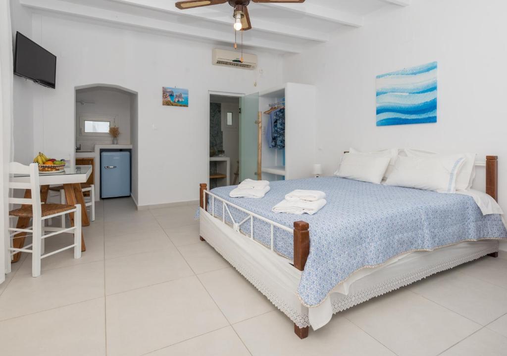 Sarantis Suites & Apartments في Provatas: غرفة نوم بيضاء مع سرير ومطبخ