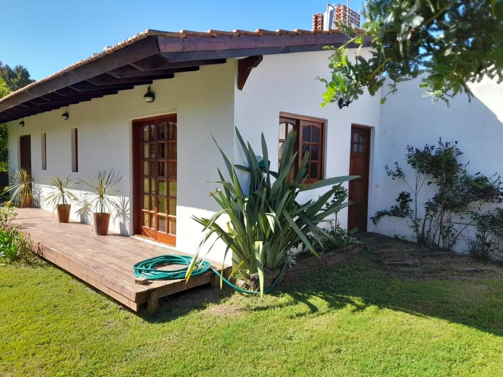 ein Haus mit einer Holzterrasse davor in der Unterkunft Arena&Mar in San Clemente del Tuyú