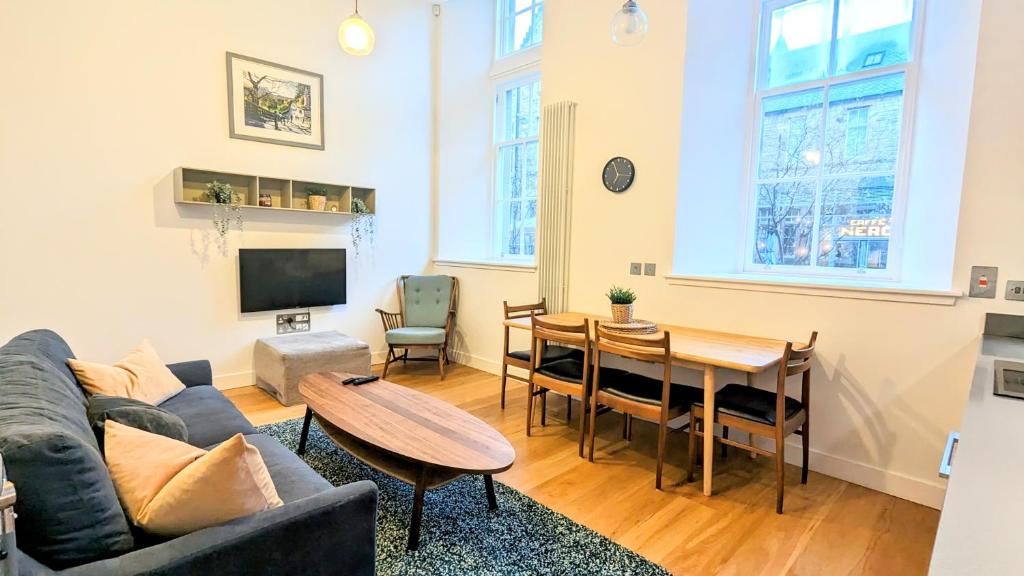 a living room with a couch and a table at Luxury One Bedroom Apartment in the City Centre in Edinburgh