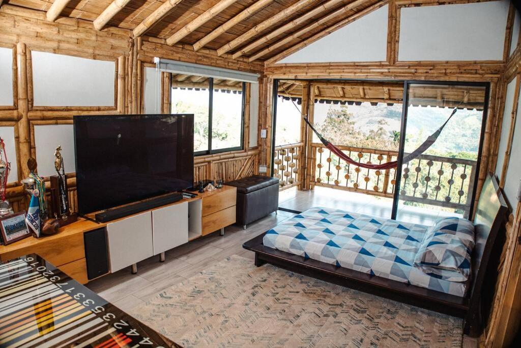 sala de estar con TV de pantalla plana en una habitación en El Edén; Un paraíso irresistible., en Barbosa
