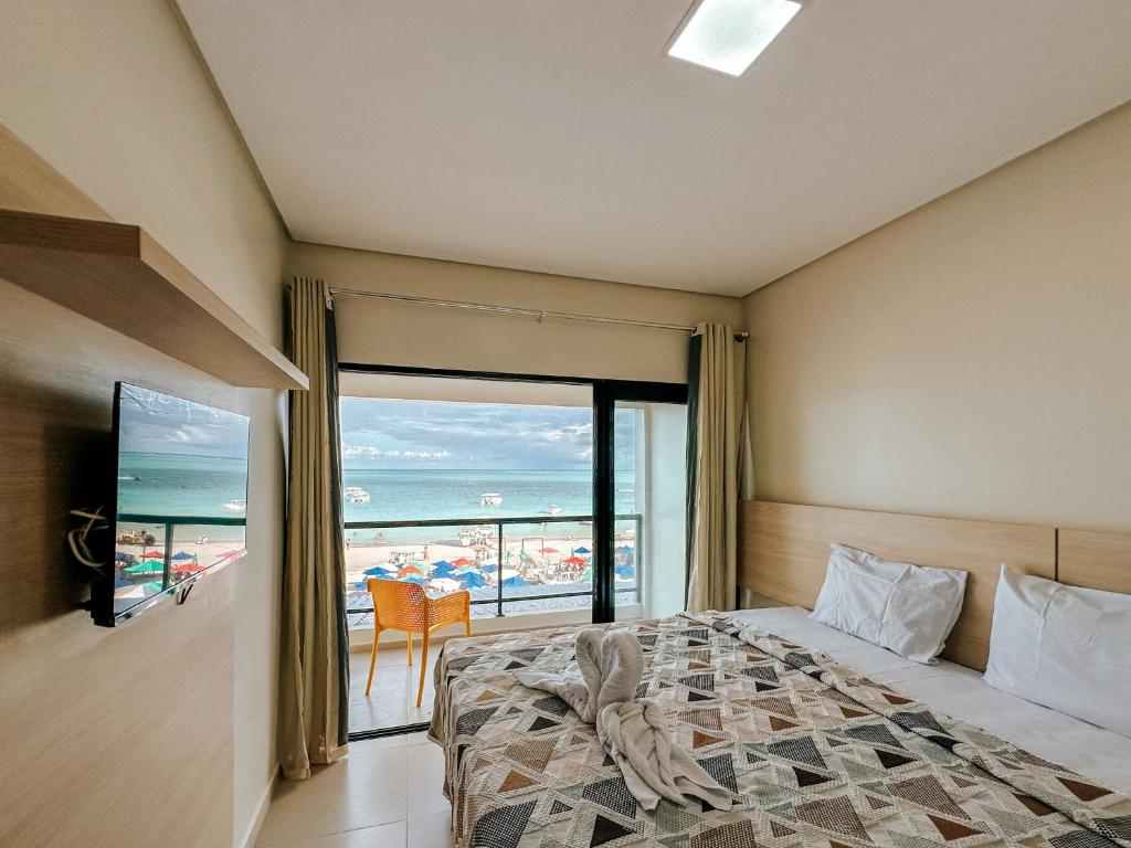 1 dormitorio con cama y vistas al océano en Pousada Villa en Maragogi