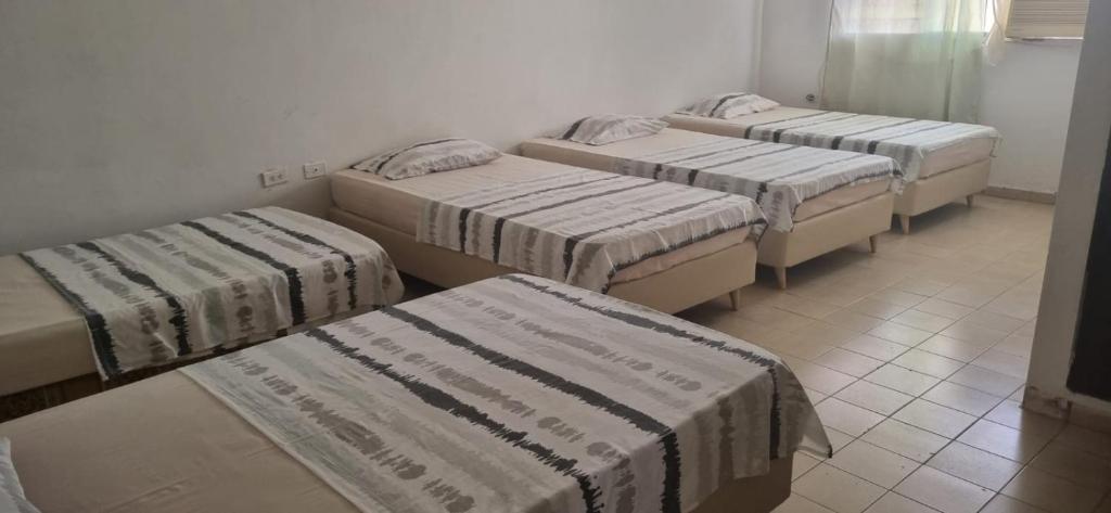 Un grupo de 4 camas en una habitación en Hotel Almirante Padilla, en Ríohacha