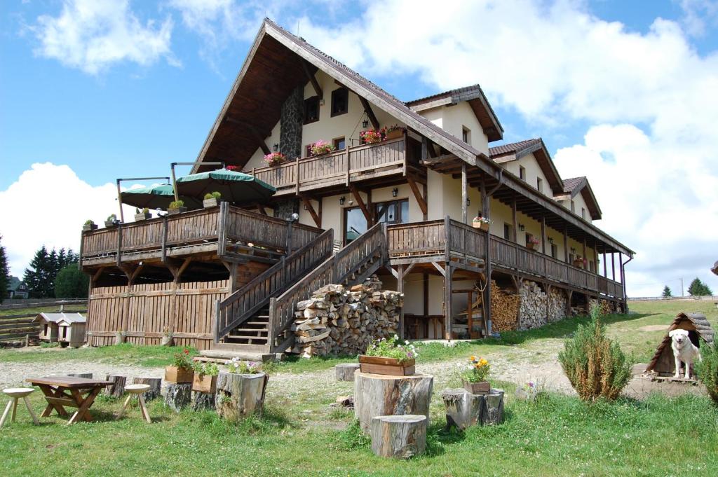 a large house with people sitting on the balcony at Cabana Moţilor in Mărişel