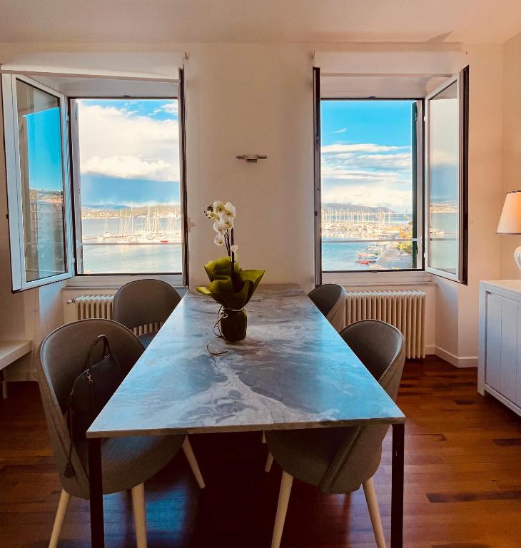 a dining room with a table with chairs and windows at About Italy Holiday Rooms and Apartments in Portovenere