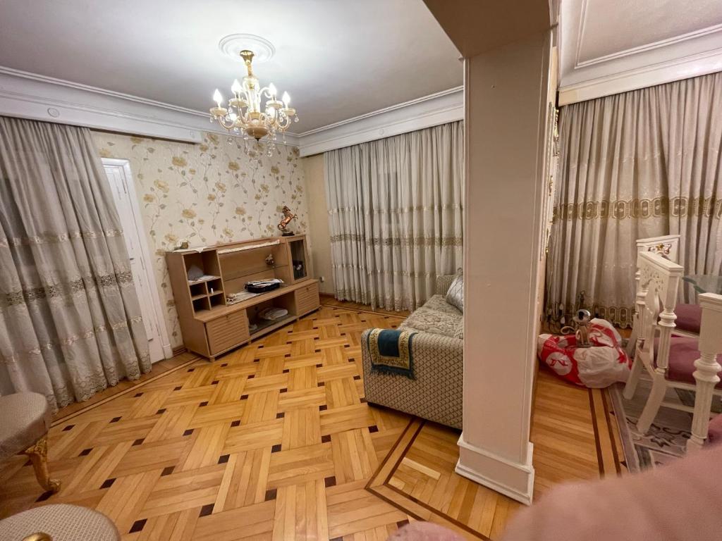 un soggiorno con pavimenti in legno e lampadario pendente di Lovely apartment 2 ad Alessandria d'Egitto