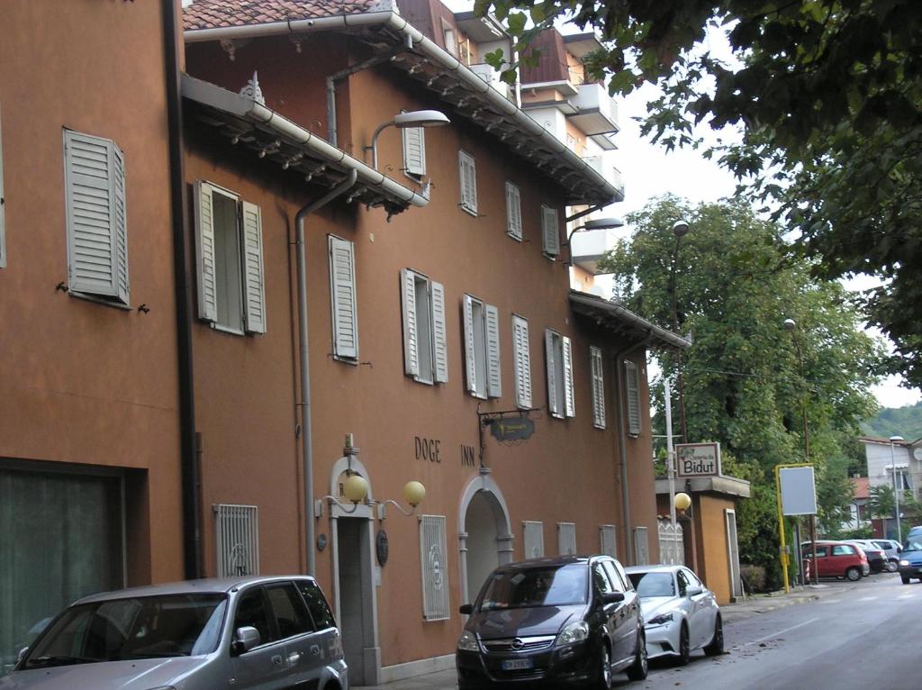 two cars parked on a street next to a building at Doge Inn in Ronchi dei Legionari