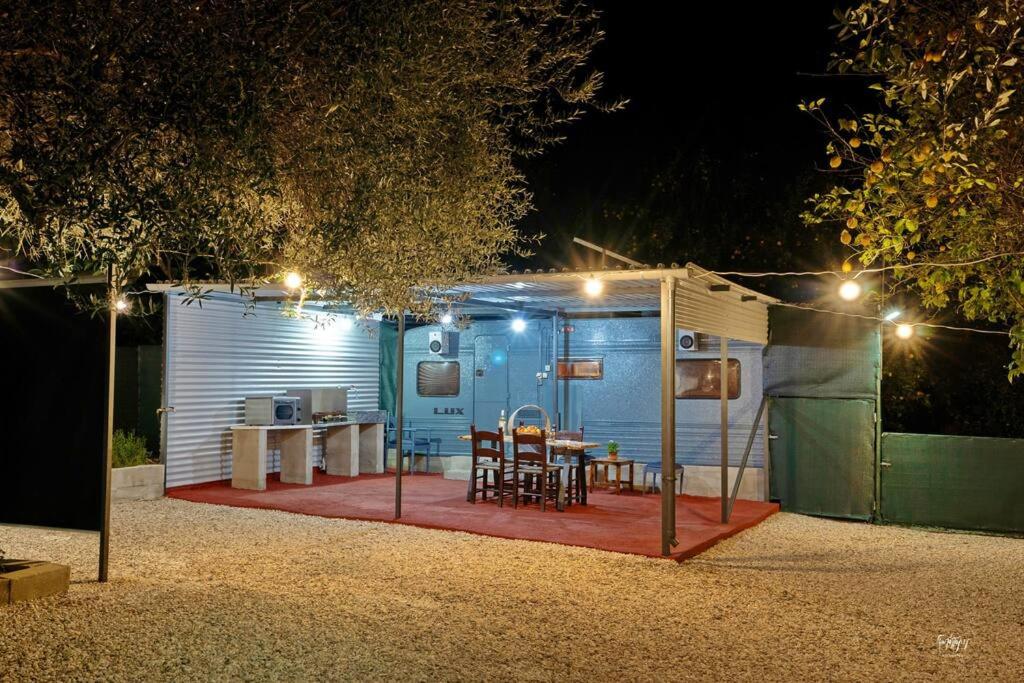 a blue shed with a table and chairs on a deck at Lemon Garden Camper in Chania Town