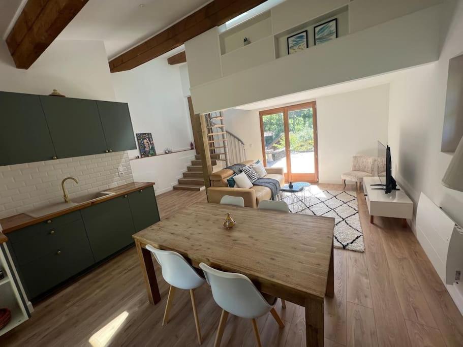 a kitchen and living room with a table and chairs at Maisonnette dans la vallée verte in Fillinges