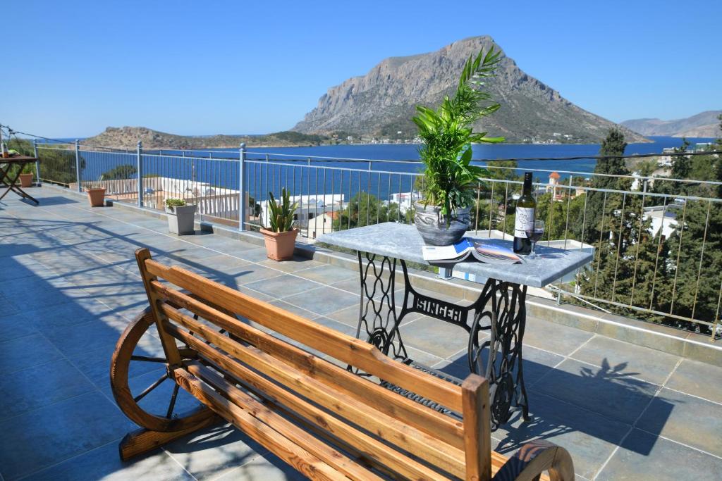 einen Tisch und eine Bank auf einem Balkon mit Blick auf das Wasser in der Unterkunft Panorama Studios & Apartments in Myrties