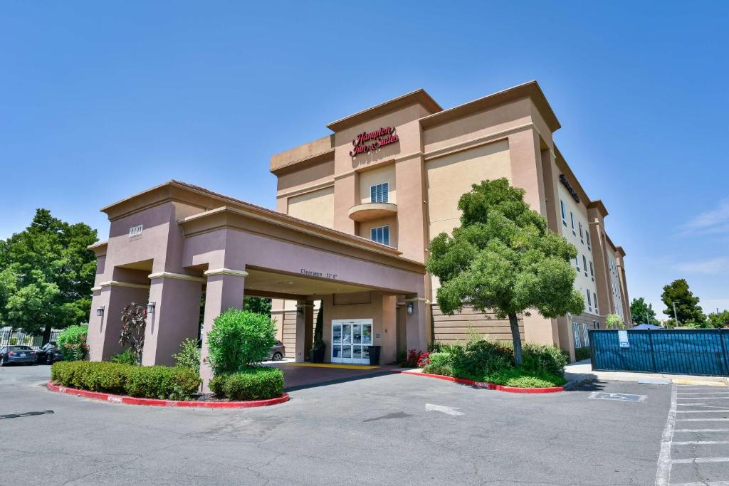 a hotel front of a building with a parking lot at Hampton Inn & Suites Pittsburg in Pittsburg