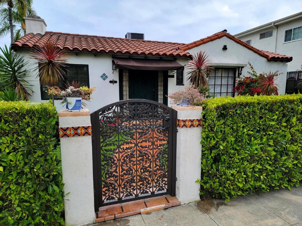 a white house with a gate in front of it at Encanto! Enchanted 3 bedroom private home near LACMA in Los Angeles