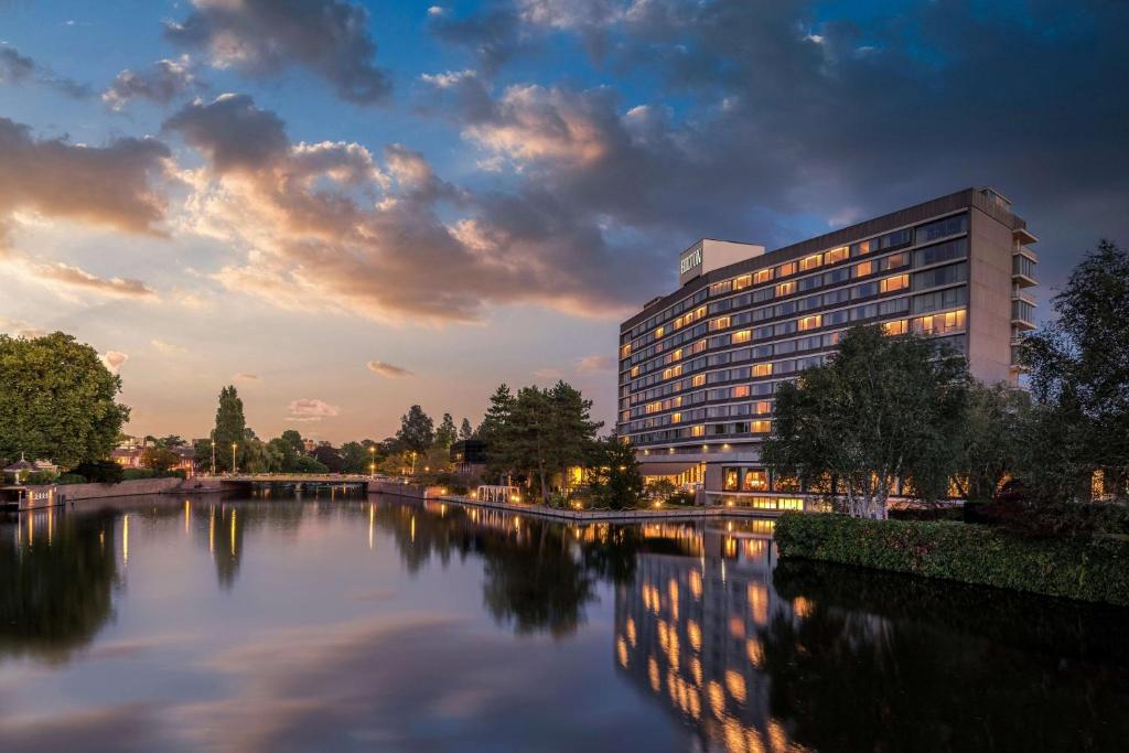 un edificio accanto a un fiume con un edificio di Hilton Amsterdam ad Amsterdam