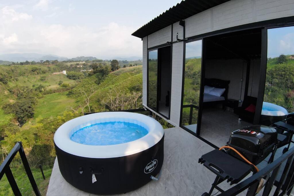 a hot tub on the deck of a house at Glamping monterrio in Santa Rosa de Cabal