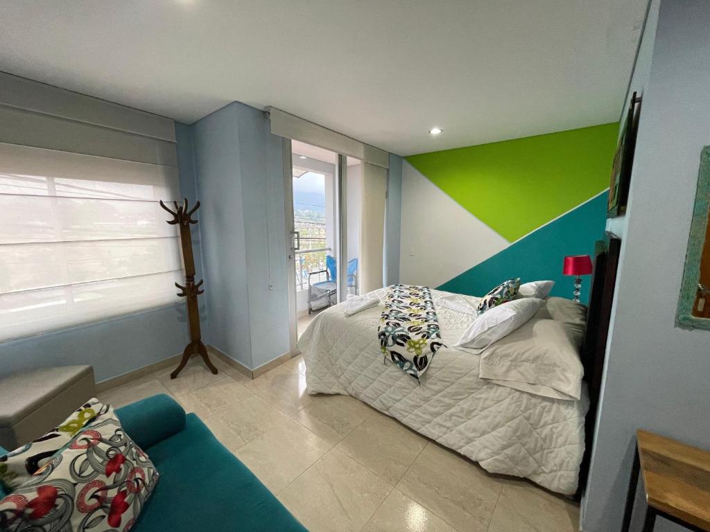 Dormitorio colorido con cama y sofá en Brisas de Guatape en Guatapé