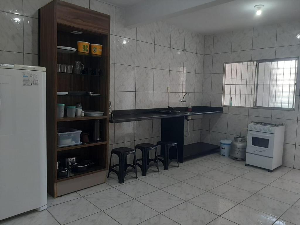 a kitchen with a counter and some stools in it at Apartamentos Central in Triunfo