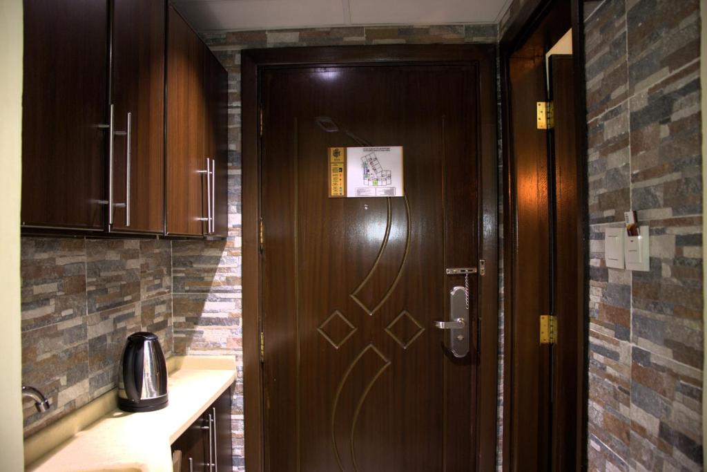 麥加的住宿－فندق لؤلؤة العنود مكة Loulouat Al Anood Hotel Mecca，厨房里挂着木门,上面有标志