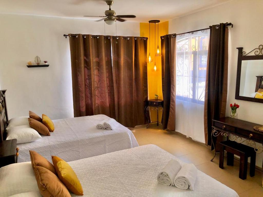 ein Hotelzimmer mit 2 Betten und einem Fenster in der Unterkunft Mayan Plaza Hermosa Habitación a 3 cuadras del Parque in Ruinas de Copán