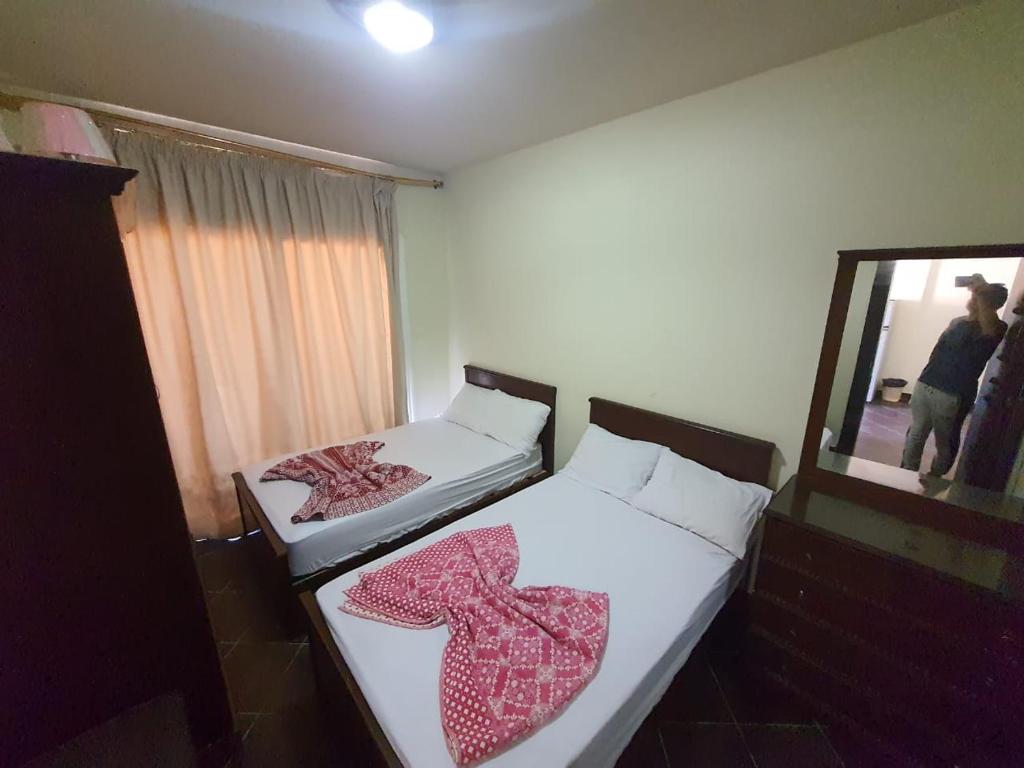 2 camas en una habitación pequeña con espejo en Porto Matroh For Family, en Marsa Matruh