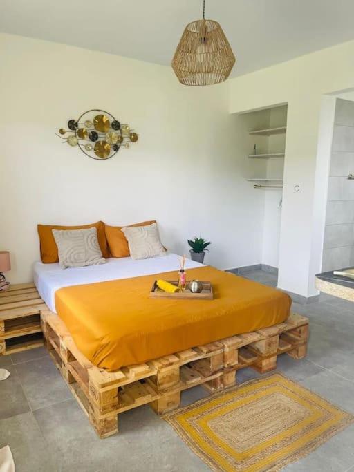 een slaapkamer met een bed gemaakt van hout bij Paisible studio tout confort in Matoury