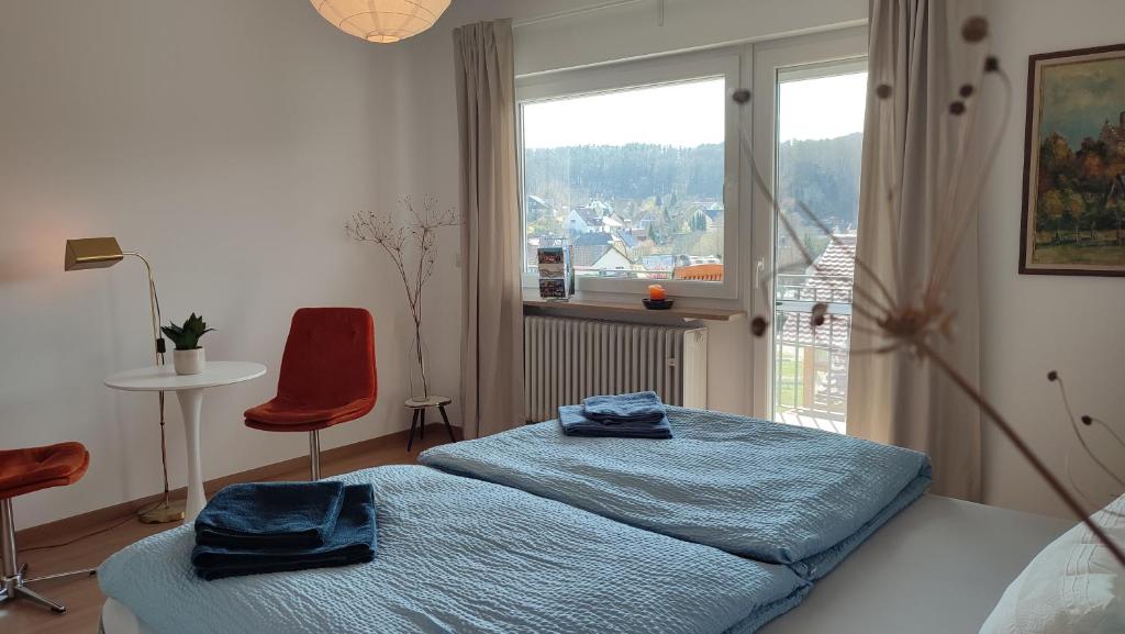 a bedroom with a bed with blue sheets and a window at Zimmer im Herzen Gößweinsteins in Gößweinstein
