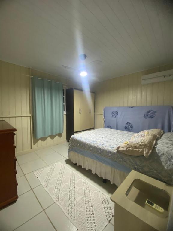 a bedroom with a bed and a light on the ceiling at Casa Completa 2 Quartos in Penha