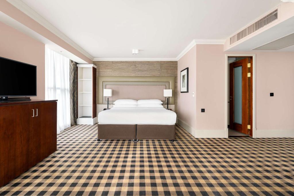 a hotel room with a bed and a flat screen tv at DoubleTree by Hilton Hotel Newcastle International Airport in Newcastle upon Tyne