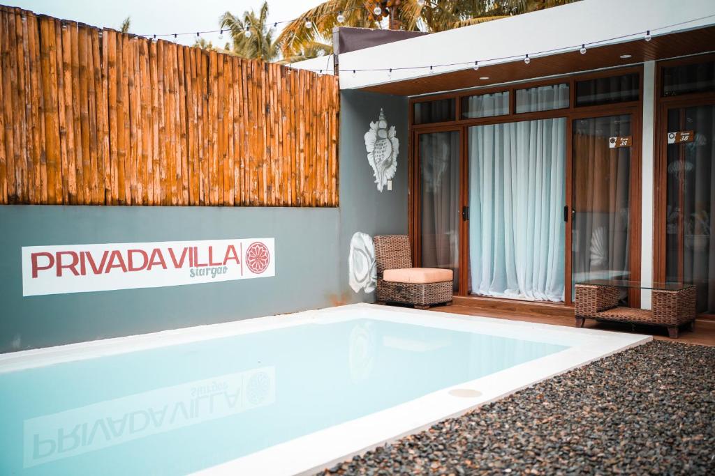 a swimming pool in front of a house at Privada Villa Siargao in General Luna
