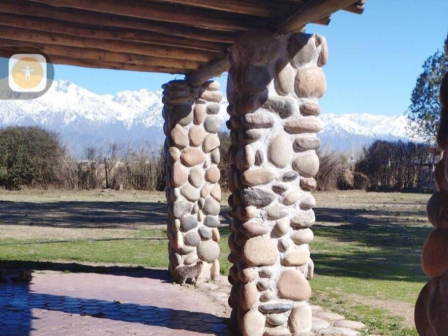 una estructura de piedra con montañas en el fondo en Posada La Escondida en San Carlos
