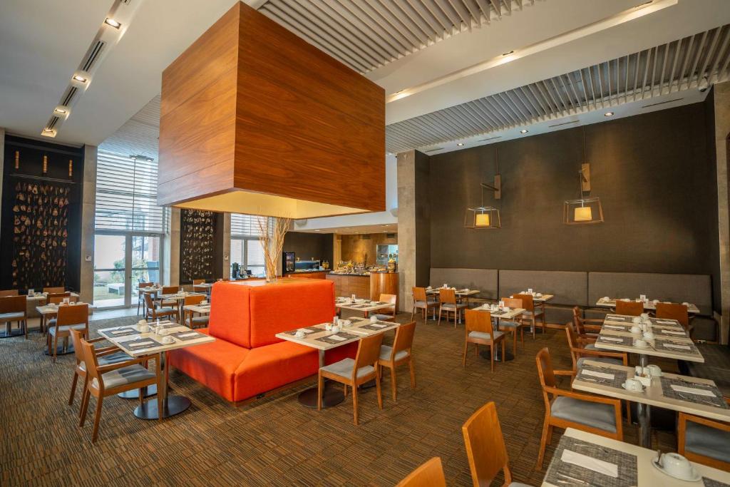 uma sala de jantar com mesas e cadeiras em Hilton Garden Inn Santiago Airport em Santiago