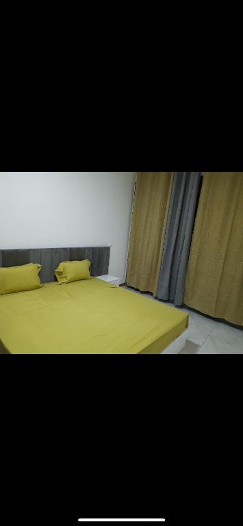 a bedroom with a yellow bed with two pillows at Pensão lopes in São Tiago