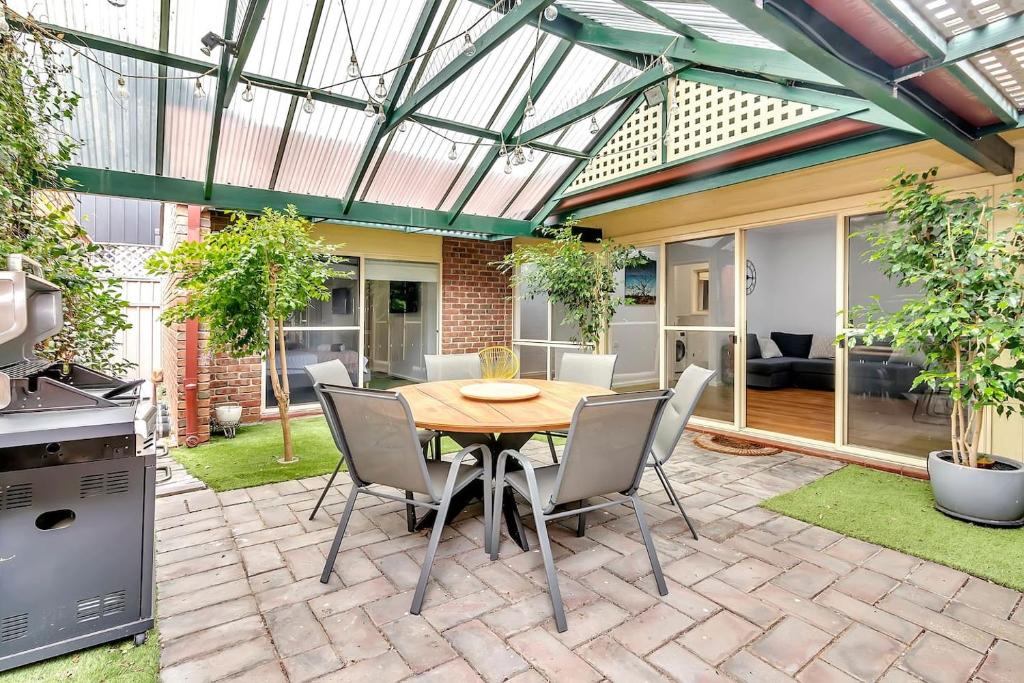 a patio with a table and chairs in a yard at Brompton Bliss - A Relaxed Northern Adelaide Retreat in Bowden