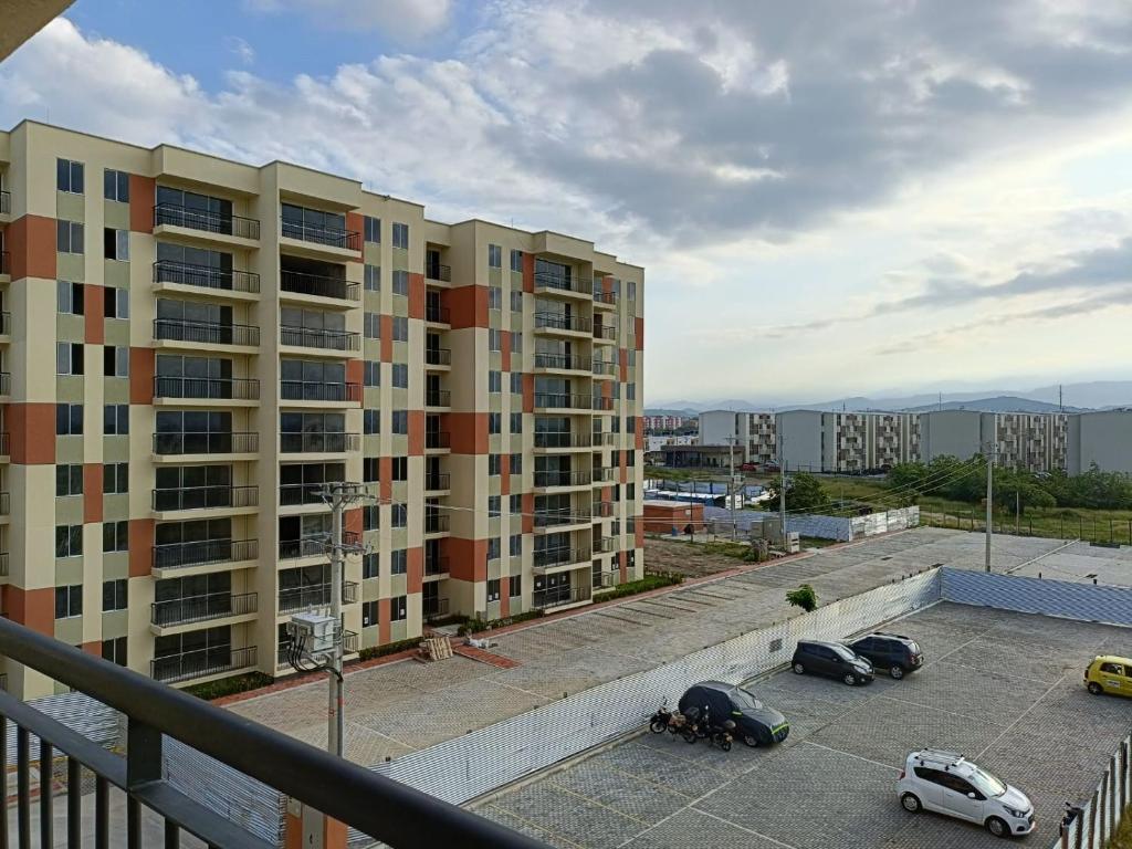 Blick auf ein Gebäude mit Autos auf einem Parkplatz in der Unterkunft Apartamento completo 3 habitaciones in Neiva