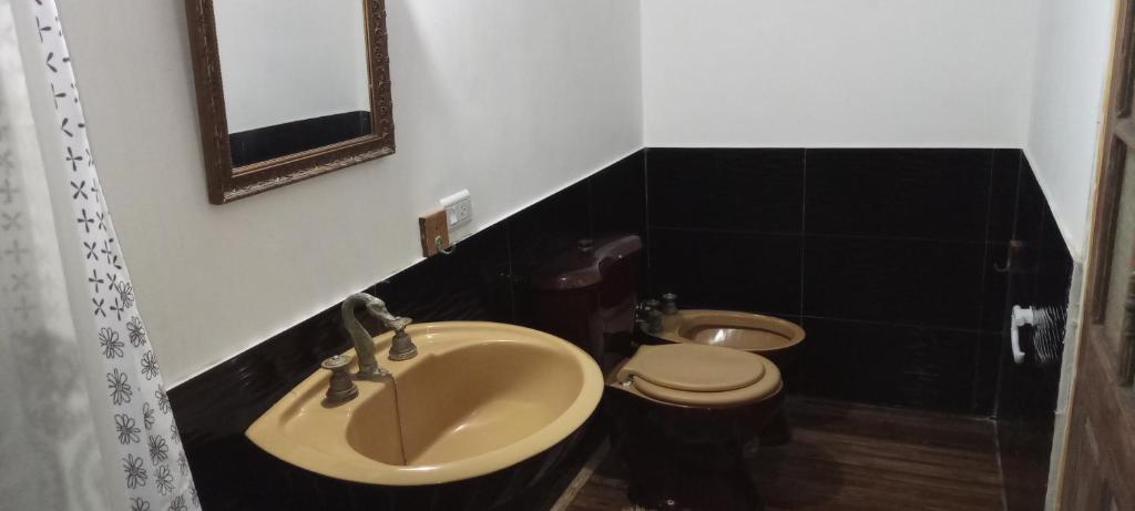 uma casa de banho com um lavatório e um WC em Hostal Adelita em Moisés Ville