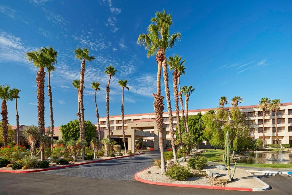 une rangée de palmiers devant un hôtel dans l'établissement DoubleTree by Hilton Golf Resort Palm Springs, à Cathedral City