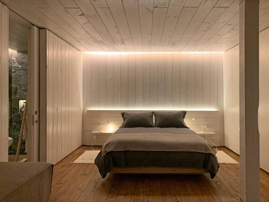 um quarto com uma cama com uma parede branca em Espectacular Loft, a pasos del mar em Curanipe