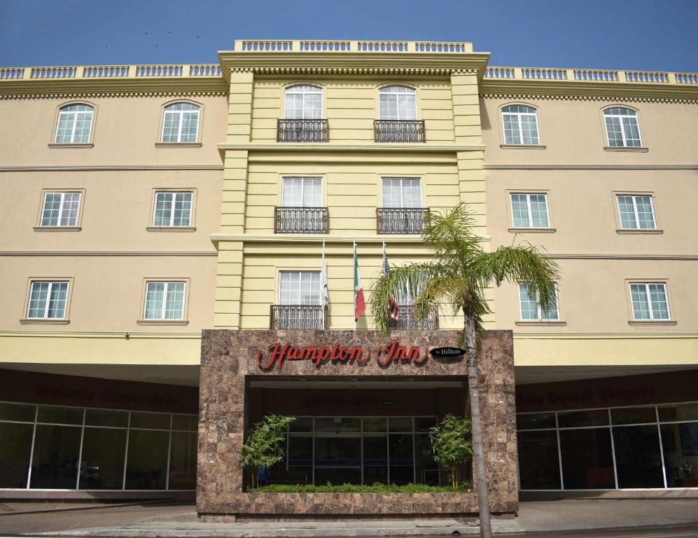 un grand bâtiment avec un panneau devant lui dans l'établissement Hampton Inn Tampico Zona Dorada, à Tampico