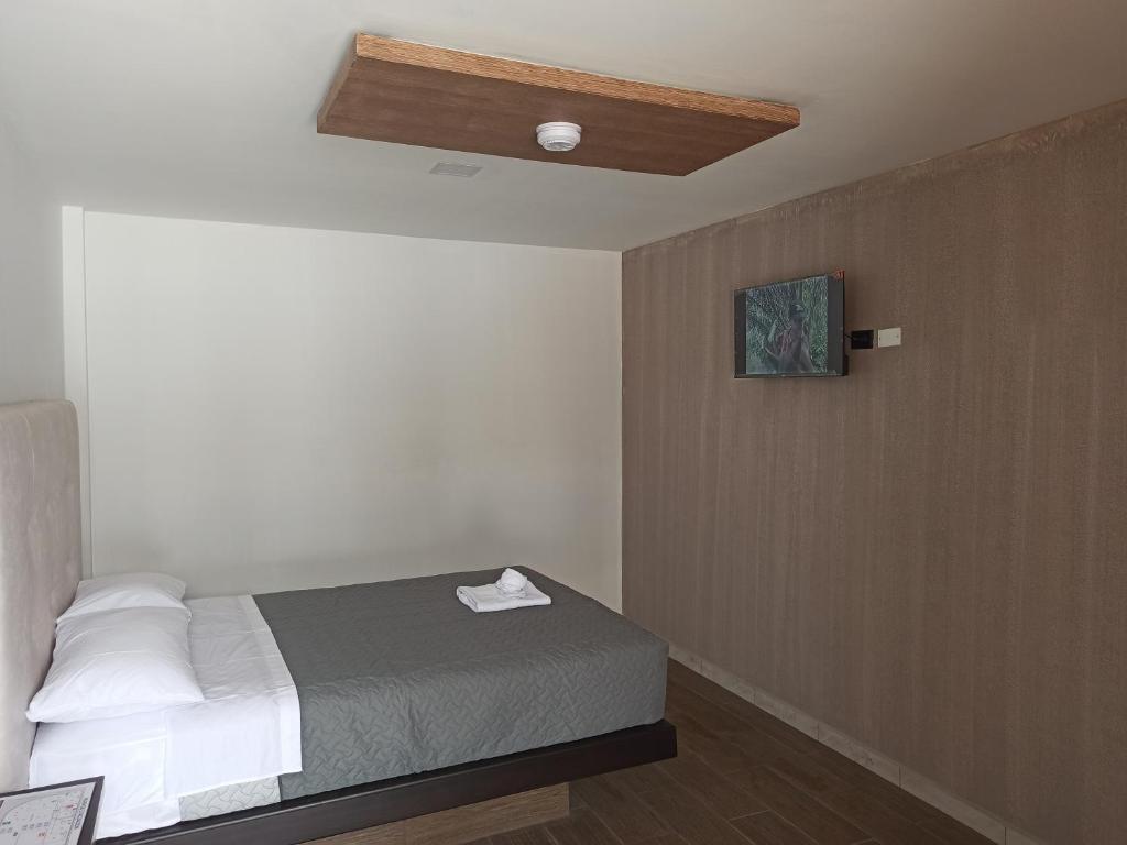 Hostal Zafiro في Sangolquí: غرفة نوم بسرير وسقف