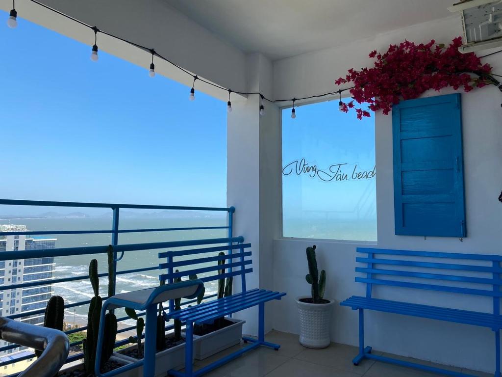 a balcony with blue benches and a view of the ocean at Duyên's Homestay - Căn hộ Sơn Thịnh 1 in Vung Tau