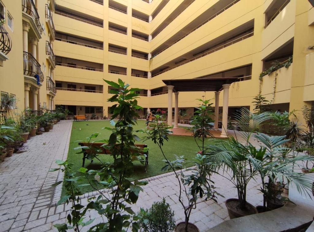 Un edificio con un patio con bancos y plantas. en Comfortia Guest House 2 Bed DringDining, en Karachi