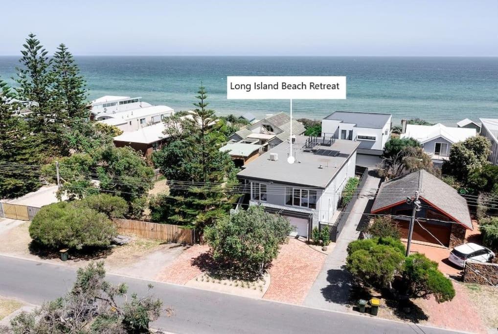 an aerial view of a house with the ocean in the background at Beach Retreat Apartment A in Frankston