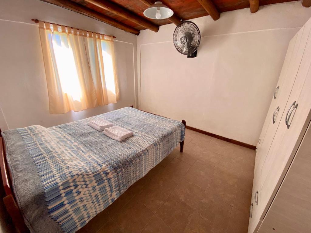 ein Schlafzimmer mit einem Bett mit einer blauen karierten Decke in der Unterkunft Los Cardenales in San José