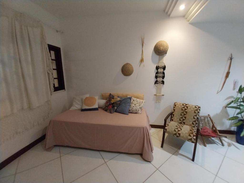 1 dormitorio con 1 cama y 1 silla en Casa em Village com piscina e perto da praia, en Salvador